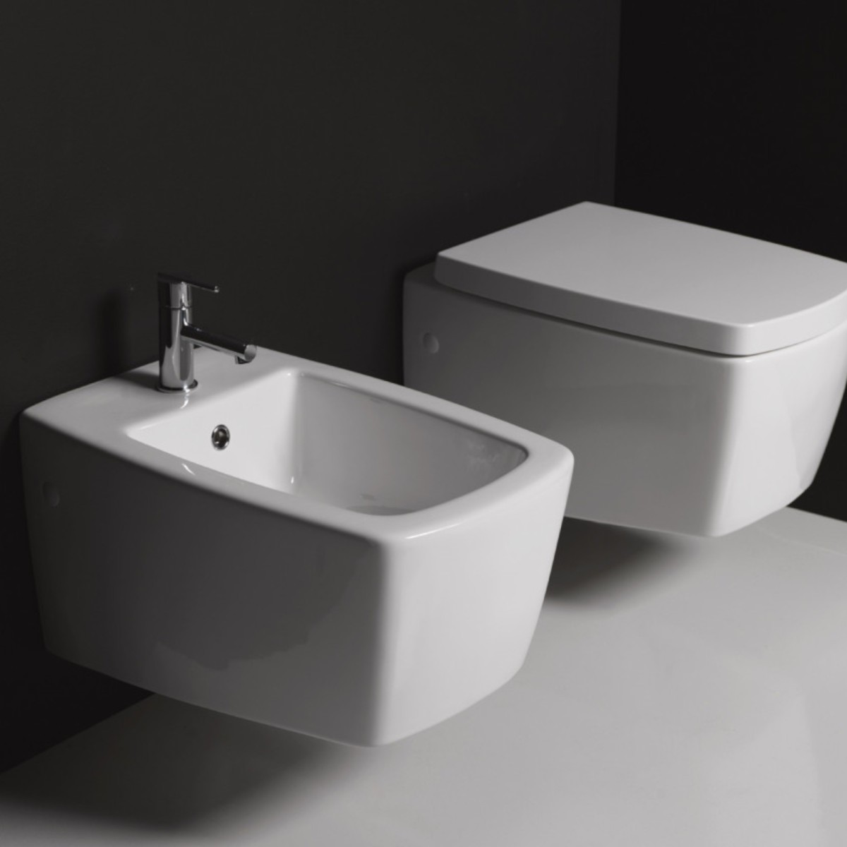 Coppia di sanitari sospesi installazione a muro serie Rayx composta da Bidet e WC con coprivaso slim a chiusura rallentata.